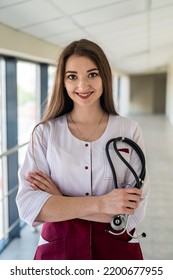 A Portrait Of A Girl Nurse Alone Who Is Standing Beautifully In The Hospital. Concept Of Medicine. A Nurse In The Corridor