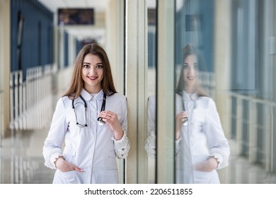 A Portrait Of A Girl Nurse Alone Who Is Standing Beautifully In The Hospital. Concept Of Medicine. A Nurse In The Corridor