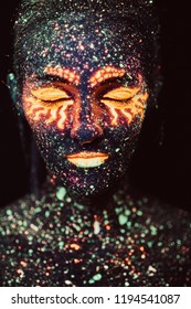 Portrait of a girl painted in fluorescent powder. Halloween concept.