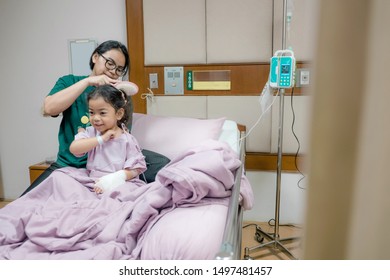 Portrait Of Girl Patient And Mother Comb Hair In Hospital Childrens Ward.