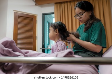 Portrait Of Girl Patient And Mother Comb Hair In Hospital Childrens Ward.