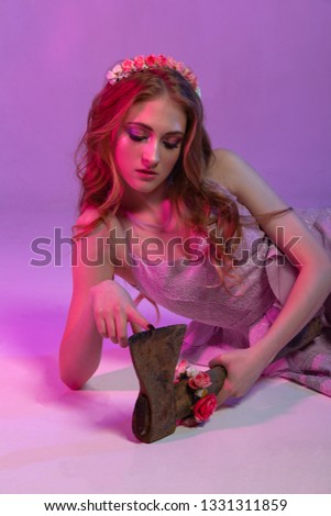 Portrait of a girl in a pink dress with an ax.