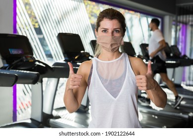 Portrait Of Girl In Protective Mask In A Sports Club Giving Thumbs Up. High Quality Photo