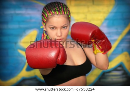 Portrait of a girl with red boxing gloves over graffiti background