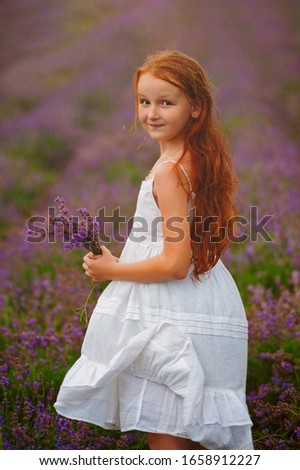 Portrait of a girl with red wet hair in lavender field in rainy day. It's a nasty day. Provence