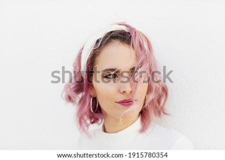 Portrait of girl with short wavy pink hair and white headband on