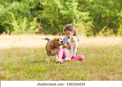 Portrait of girl sitting on a grassy ground together with her pets