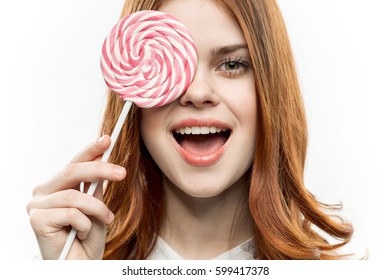 Portrait of a girl smiling with a large round candy