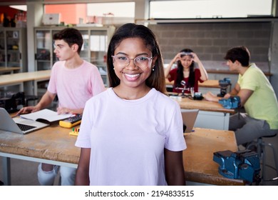 Portrait of a girl standing in a technology class looking at the camera. Vocational training students in the classroom studying electronics, robotics, electricity or some kind of technical college - Shutterstock ID 2194833515