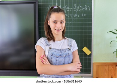 Portrait Of Girl Student Of Teenager 13 Years Old At School Near Chalk Board. Schoolgirl In Classroom At Math Lesson