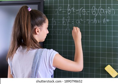 Portrait Of Girl Student Of Teenager 13 Years Old At School Near Chalk Board. Schoolgirl In Classroom At Math Lesson