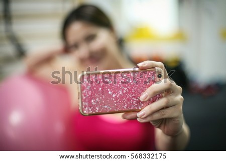 Portrait of girl taking selfie picture in an old gym. Focus is on hand.