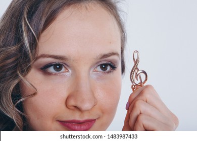 portrait of a girl with a violin key in her hands on a white background. The concept of advertising musical instruments, fashion, symbols - Shutterstock ID 1483987433