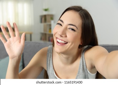 Portrait Of A Girl Waving Recording Video Or Taking Selfie At Home