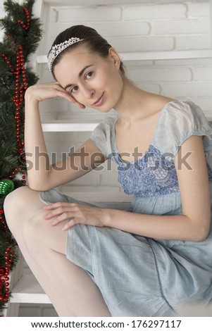 Portrait of a girl in a white ladder with new year's decorations