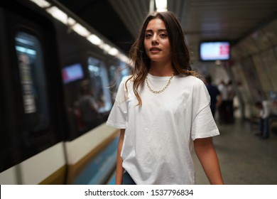 portrait of girl in white t-shirt and blue jean pants in the metro