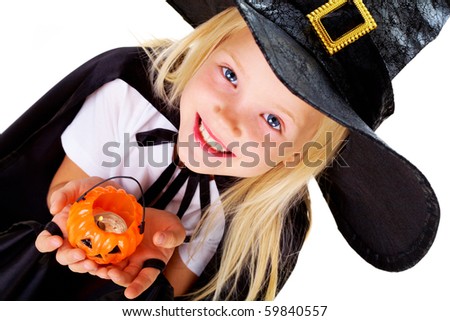 Portrait of girl in witch costume and small pumpkin candle in hands