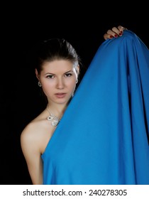 Portrait Of The Girl  Wrapped Up Dark Blue Fabric On A Black Background