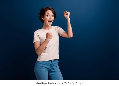 Portrait of glad overjoyed lady specialist got promotion at work celebrate raise fists isolated on dark blue color background