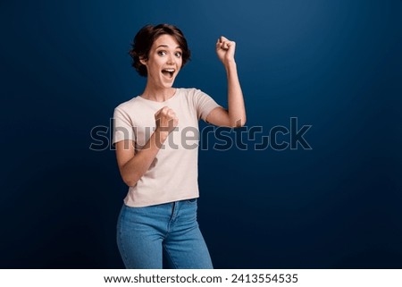 Portrait of glad overjoyed lady specialist got promotion at work celebrate raise fists isolated on dark blue color background