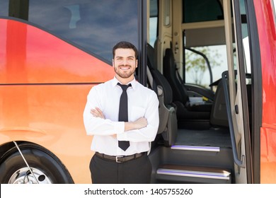 Portrait of good looking driver standing arms crossed outside intercity bus