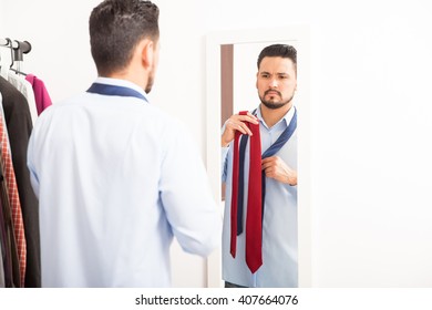 Portrait Of A Good Looking Young Man Getting Dressed In A Bedroom And Choosing The Right Tie For Work