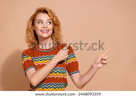 Portrait of good mood girl with foxy hair wear knit t-shirt directing look at season sale empty space isolated on beige color background