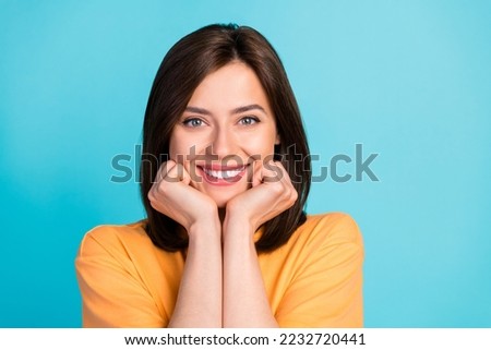 Portrait of good mood pretty woman long hairstyle wear yellow t-shirt toothy smiling arms on cheekbones isolated on blue color background