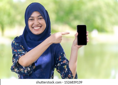 Portrait of good-looking Happy young teenager Muslim islamic asian university girl hold mobile phone