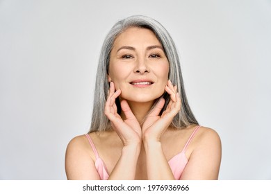 Portrait of gorgeous beautiful middle aged mature asian woman, senior older 50 year lady looking at camera touching her face isolated on white. Ads of lifting anti wrinkle skin care, spa.