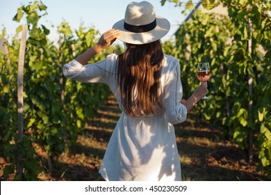 Portrait of a gorgeous brunette woman having wine fun in the vineyards. - Powered by Shutterstock