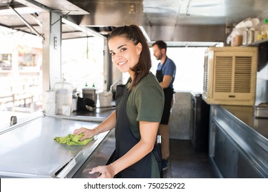 Portrait of a gorgeous cook cleaning her food truck and getting ready to prepare some food - Powered by Shutterstock