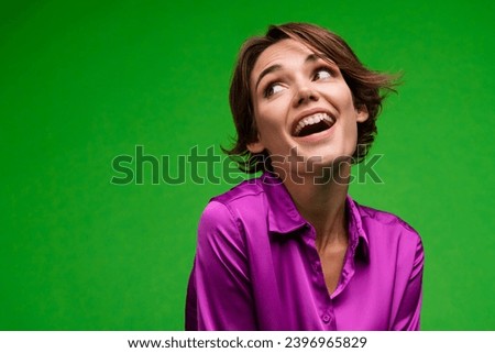 Portrait of gorgeous creative positive lady toothy smile look interested empty space isolated on green color background