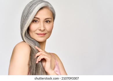 Portrait of gorgeous happy middle aged mature asian woman, senior older 50s lady pampering her hair looking at camera isolated on white. Ads of anti age skin and hair care spa. Copy space.