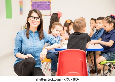 Portrait Of A Gorgeous Hispanic Preschool Teacher Loving Her Job And Having Fun With Her Pupils