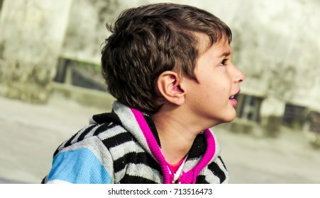 Portrait of a gorgeous little boy smiling and looking up and enjoying the moment, for background. - Shutterstock ID 713516473
