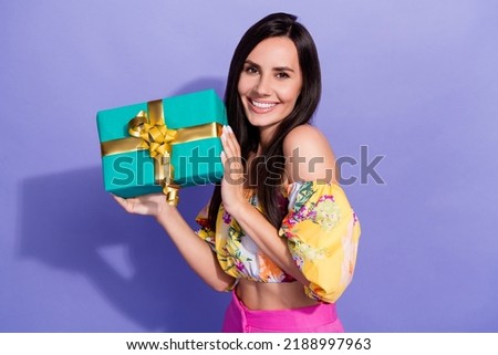 Portrait of gorgeous positive person arms hold giftbox toothy smile isolated on purple color background