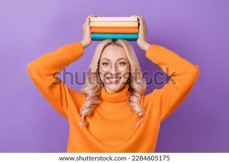 Portrait of gorgeous satisfied woman elegant hairdo wear pullover turtleneck arms hold book over head isolated on violet color background