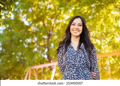 Portrait Of A Gorgeous Young Hispanic Woman Hanging Out At A Park And Smiling