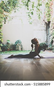 Portrait of gorgeous young woman practicing yoga indoor. Beautiful girl practice cobra asana in class.Calmness and relax, female happiness.Vertical, blurred background - Shutterstock ID 515885899