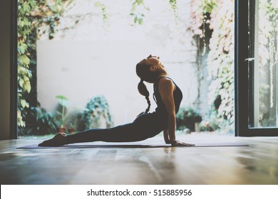 Portrait of gorgeous young woman practicing yoga indoor. Beautiful girl practice cobra asana in class.Calmness and relax, female happiness.Horizontal, blurred background - Shutterstock ID 515885956