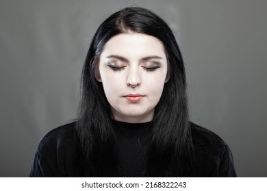 Portrait Of A Goth Style Girl With Closed Eyes Against Grray Background