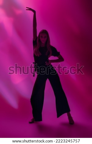Portrait of a graceful beautiful girl dancing at studio in black top, pants and shoes. Beauty and Fashion. Modern ballet dances.