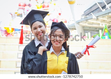 Portrait of Graduate women students wearing graduation hat and gown. Education concept. selective focus.