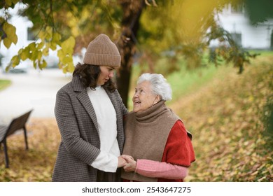 Portrait of a granddaughter on an autumn walk in the park with her grandmother. - Powered by Shutterstock