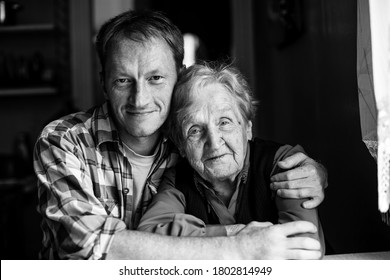 Portrait Of Grandma With Her Adult Grandson. Black And White Photography.