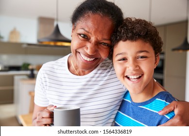 Portrait Of Grandmother Drinking Coffee With Grandson In Kitchen At Home - Powered by Shutterstock