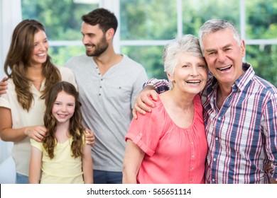 Portrait of grandparents with family at home