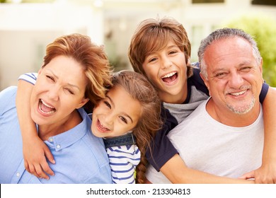 Portrait Of Grandparents And Grandchildren In Garden