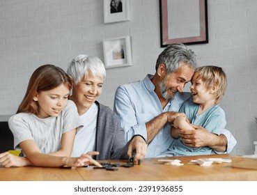 Portrait of grandparents and grandchildren having fun together playing domino game at home - Powered by Shutterstock